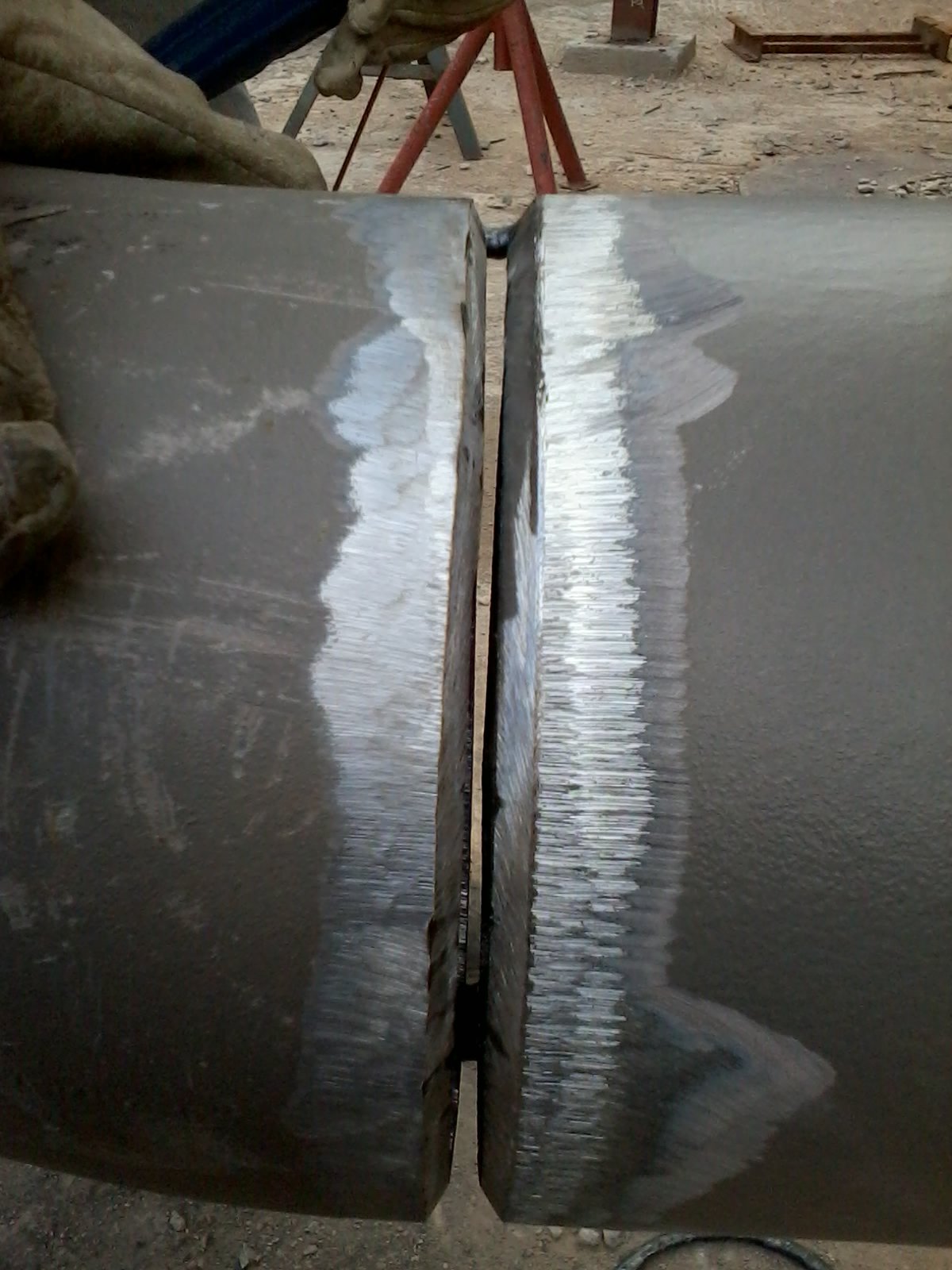 Prepared edges of two heavy steel plate sections ready for marine welding.